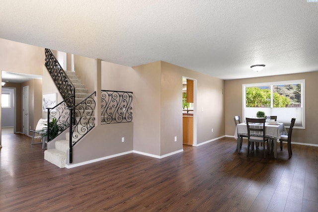 5501 Maui Ct, West Richland, WA 99353 - dining area featuring dark wood-style floors, stairs, baseboards, and a textured ceiling