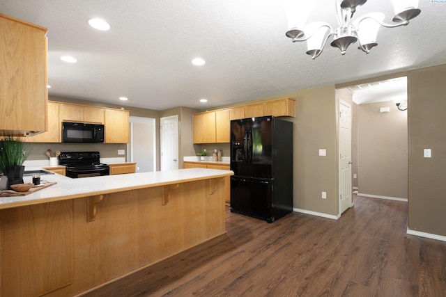 5501 Maui Ct, West Richland, WA 99353 - kitchen with black appliances, a peninsula, light countertops, a chandelier, and dark wood-style flooring