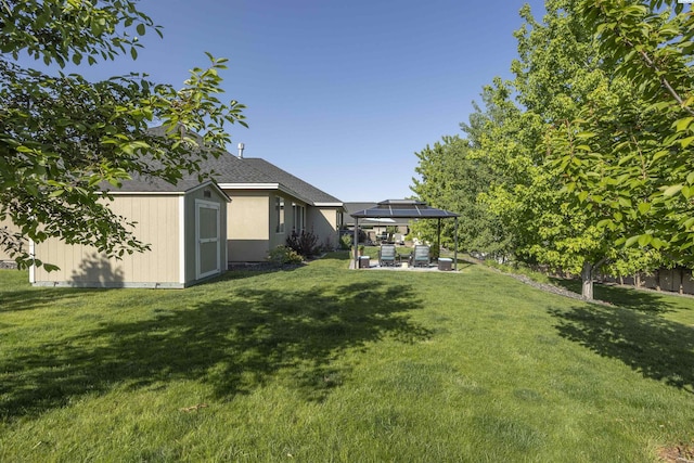 view of yard featuring an outdoor structure, a patio, a gazebo, and a shed