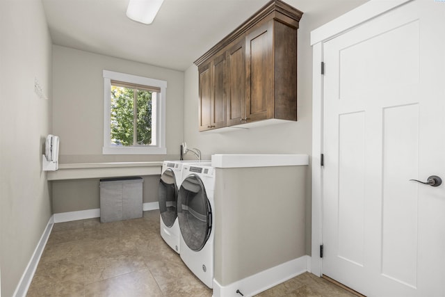 laundry room with cabinet space, baseboards, and washing machine and dryer