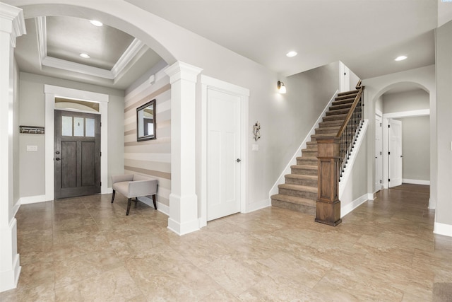 entryway featuring crown molding, arched walkways, recessed lighting, baseboards, and stairway
