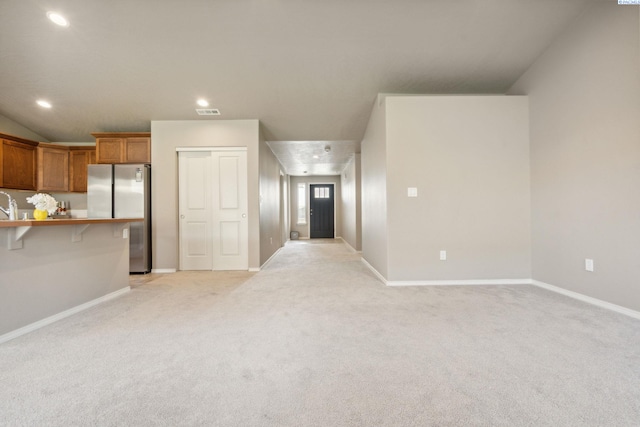 6834 W 25th Ave, Kennewick, WA 99338 - unfurnished living room featuring visible vents, baseboards, a sink, recessed lighting, and light colored carpet