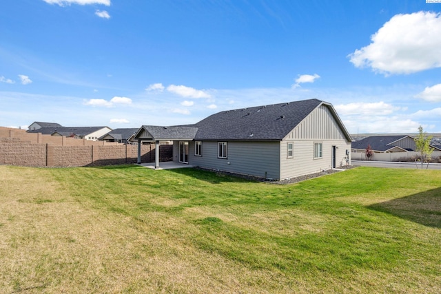 6834 W 25th Ave, Kennewick, WA 99338 - rear view of property with a lawn, board and batten siding, a patio area, a fenced backyard, and a shingled roof