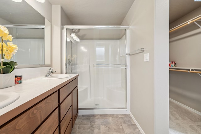 6834 W 25th Ave, Kennewick, WA 99338 - bathroom with a shower stall, a sink, a spacious closet, and baseboards