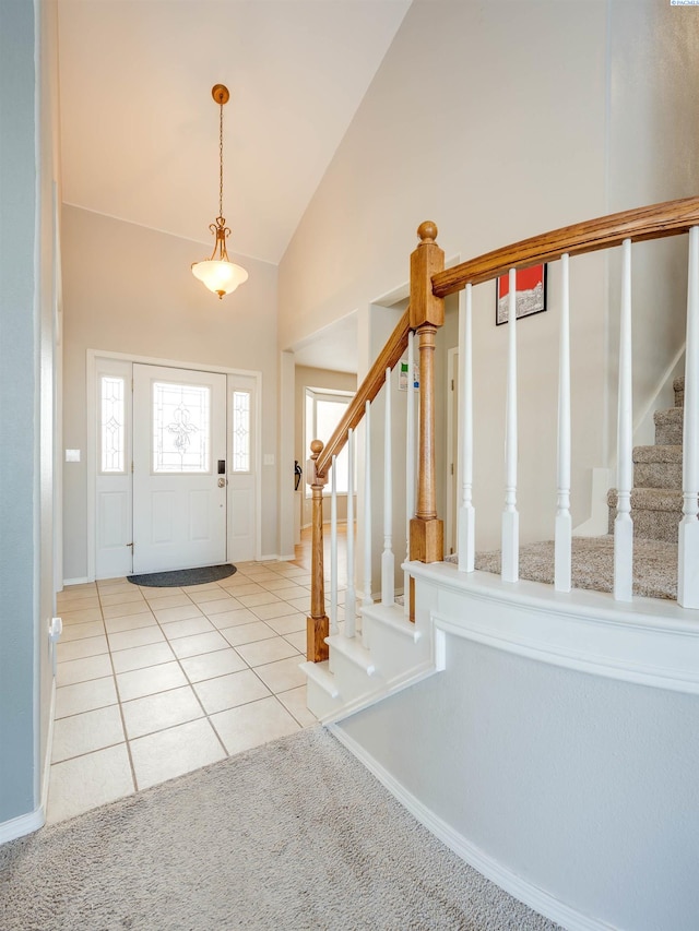 foyer featuring high vaulted ceiling, stairway, and light tile patterned floors