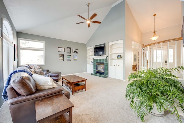 carpeted living room featuring a fireplace, high vaulted ceiling, ceiling fan, and built in features