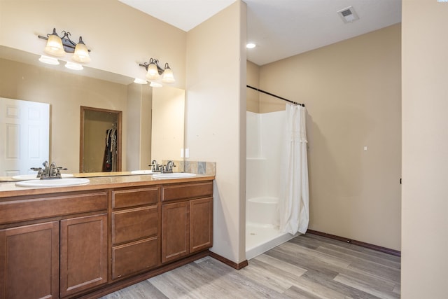 615 N Larkspur Dr, Othello, WA 99344 - full bathroom featuring baseboards, double vanity, visible vents, a sink, and wood finished floors