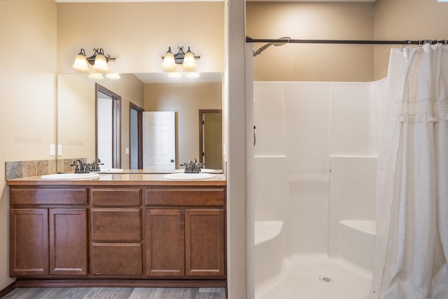 615 N Larkspur Dr, Othello, WA 99344 - full bathroom featuring a shower with shower curtain, double vanity, a sink, and wood finished floors