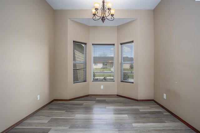 615 N Larkspur Dr, Othello, WA 99344 - empty room with baseboards, a chandelier, and wood finished floors