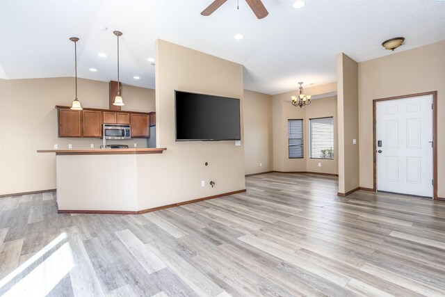 615 N Larkspur Dr, Othello, WA 99344 - unfurnished living room with baseboards, recessed lighting, ceiling fan with notable chandelier, light wood-style flooring, and lofted ceiling