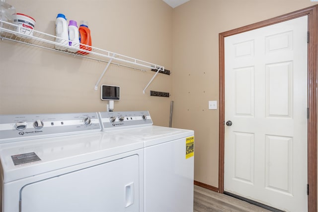 615 N Larkspur Dr, Othello, WA 99344 - washroom featuring laundry area, baseboards, light wood-type flooring, and washer and clothes dryer