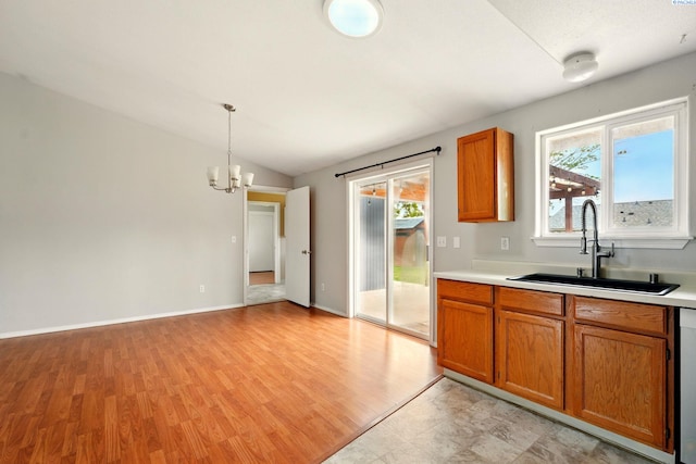 4721 Holly Way, West Richland, WA 99353 - kitchen featuring a sink, brown cabinets, healthy amount of natural light, a chandelier, and vaulted ceiling