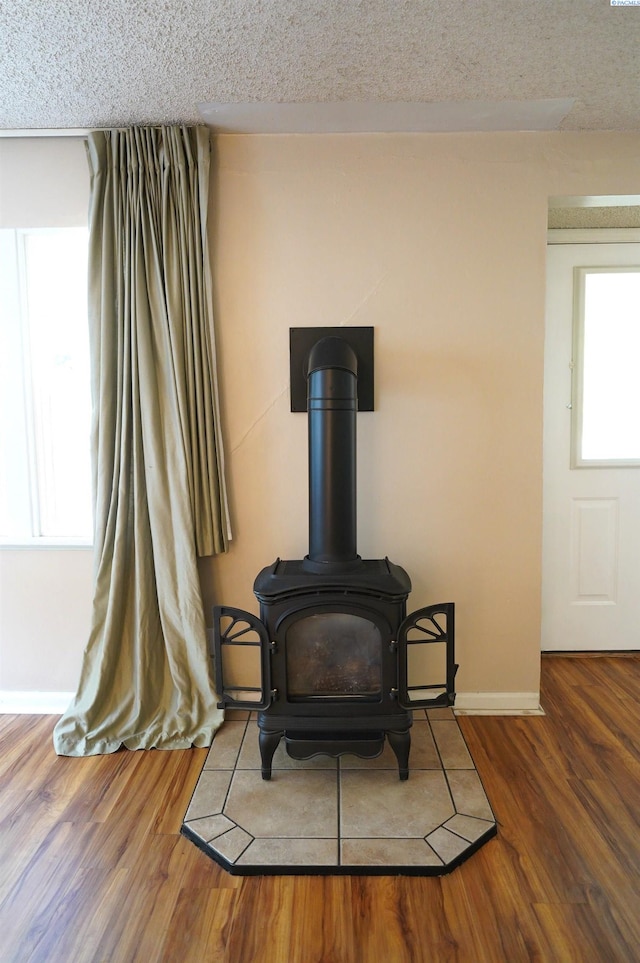 1004 NE D St, Pullman, WA 99163 - detailed view of baseboards, a wood stove, wood finished floors, and a textured ceiling