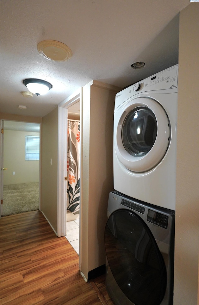 1004 NE D St, Pullman, WA 99163 - washroom featuring estacked washer and dryer, wood finished floors, and a textured ceiling