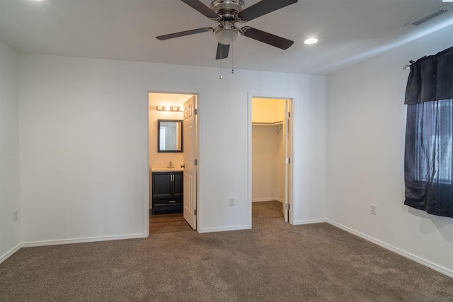 209 W 7th Ave, Warden, WA 98857 - unfurnished bedroom featuring carpet flooring, a walk in closet, baseboards, a sink, and ensuite bathroom
