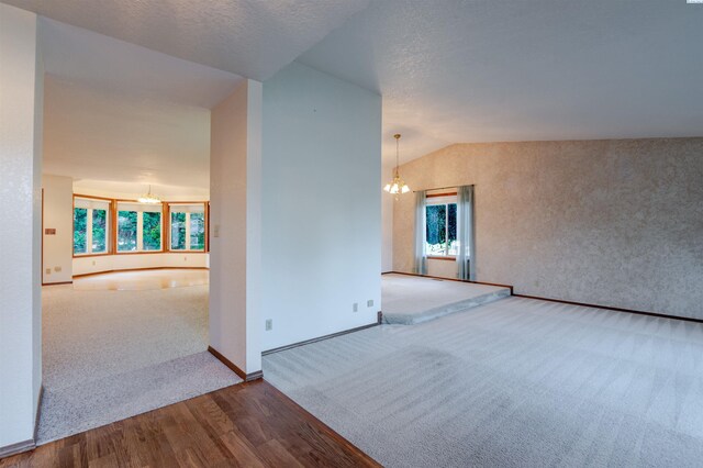 1741 April Loop, Richland, WA 99352 - empty room with a chandelier, carpet flooring, wood finished floors, and vaulted ceiling