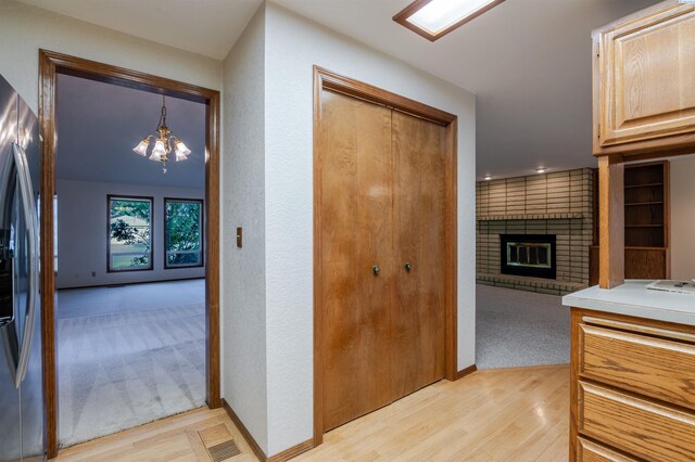 1741 April Loop, Richland, WA 99352 - hall with light wood-type flooring, a chandelier, and a textured wall