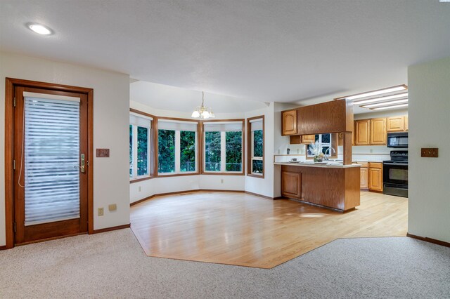 1741 April Loop, Richland, WA 99352 - kitchen with black appliances, a chandelier, light colored carpet, and light countertops