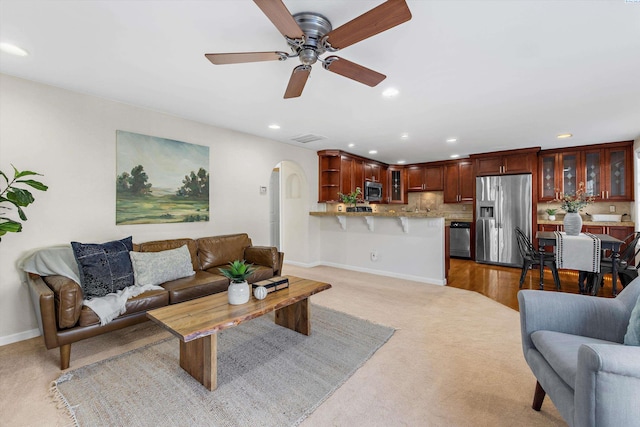 living room with ceiling fan and light colored carpet