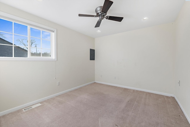 empty room featuring light colored carpet, electric panel, and ceiling fan