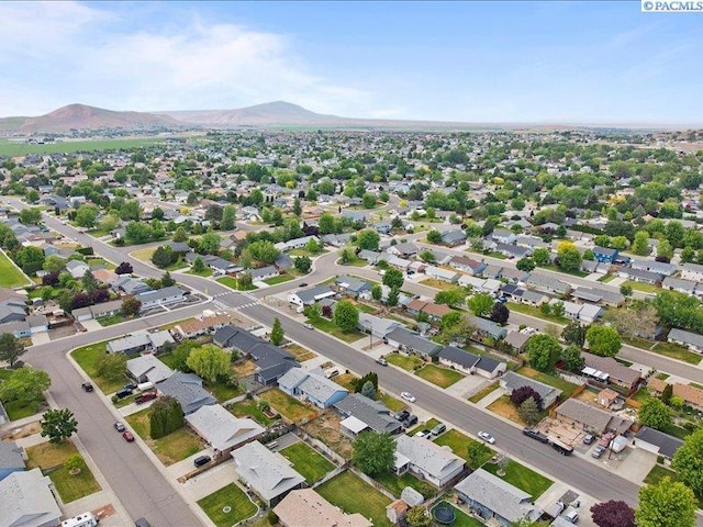 aerial view of property and surrounding area with a mountain backdrop and nearby suburban area