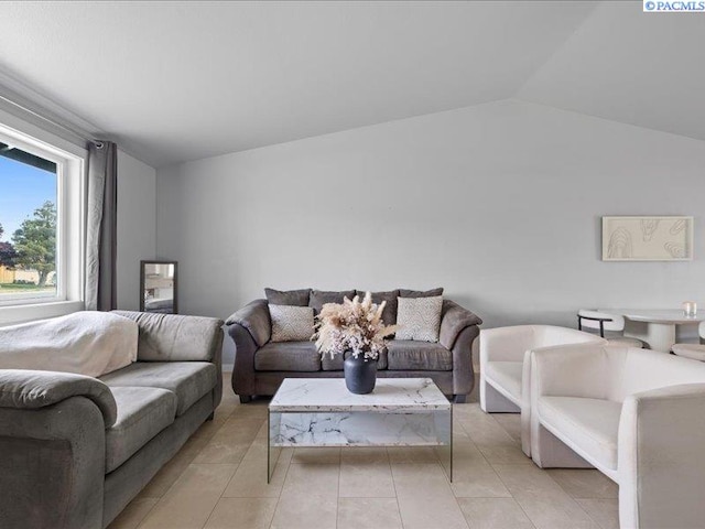 living room featuring lofted ceiling and light tile patterned floors