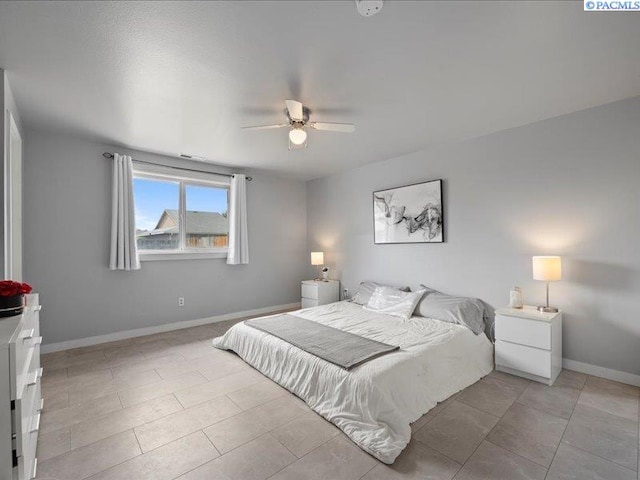 bedroom featuring baseboards, a ceiling fan, and light tile patterned floors