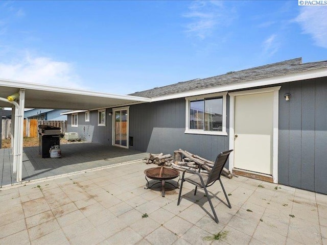 view of patio with an outdoor fire pit and fence