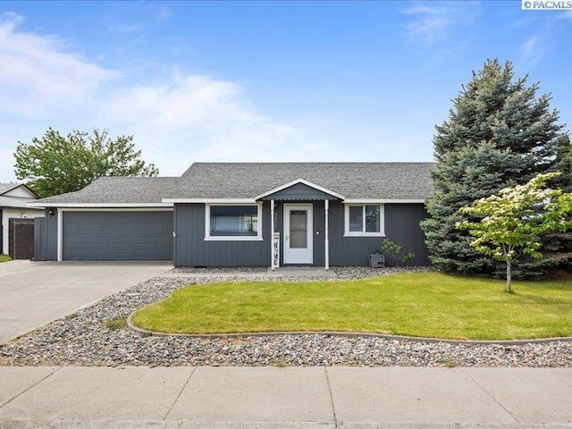 ranch-style home featuring concrete driveway, a garage, a front lawn, and roof with shingles