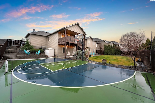 view of basketball court with tennis court and a lawn