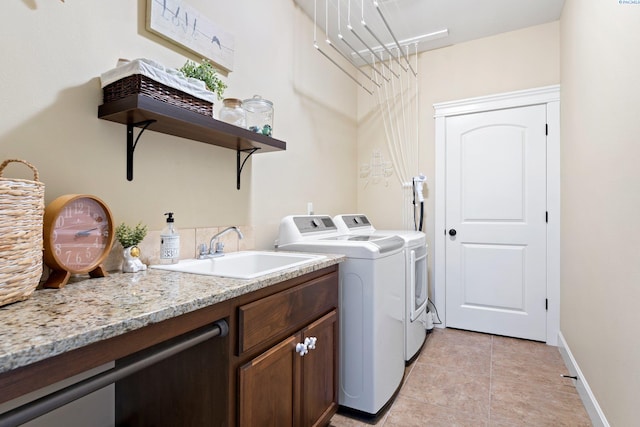 laundry area featuring cabinets, washing machine and dryer, sink, and light tile patterned floors