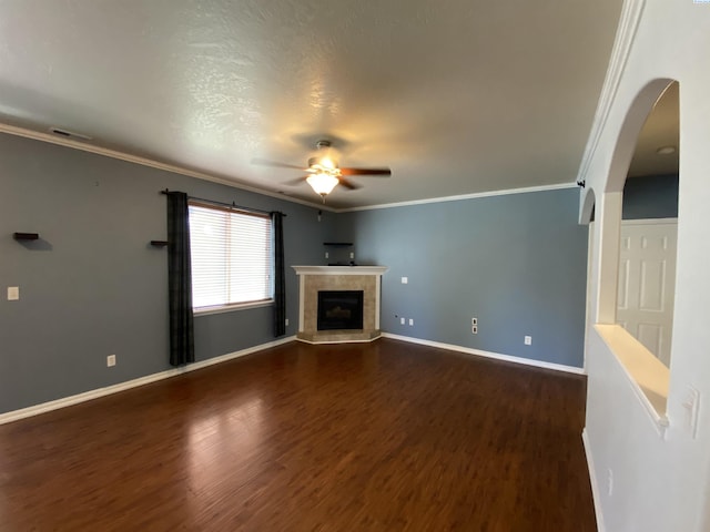 2002 Diamond Head Way, West Richland, WA 99353 - unfurnished living room with a ceiling fan, dark wood-style flooring, a tile fireplace, arched walkways, and crown molding