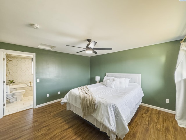 bedroom with ensuite bath, dark wood-style floors, attic access, and baseboards