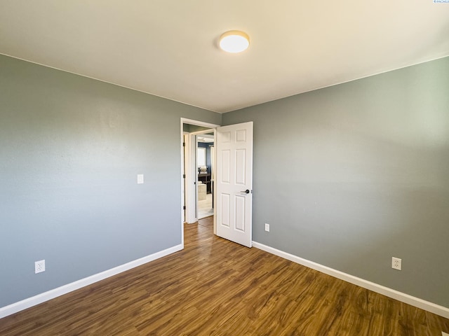 unfurnished room with wood finished floors and baseboards