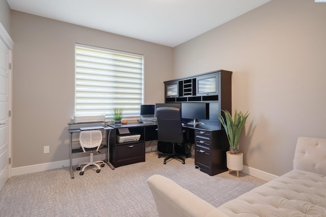 office space with baseboards and light colored carpet