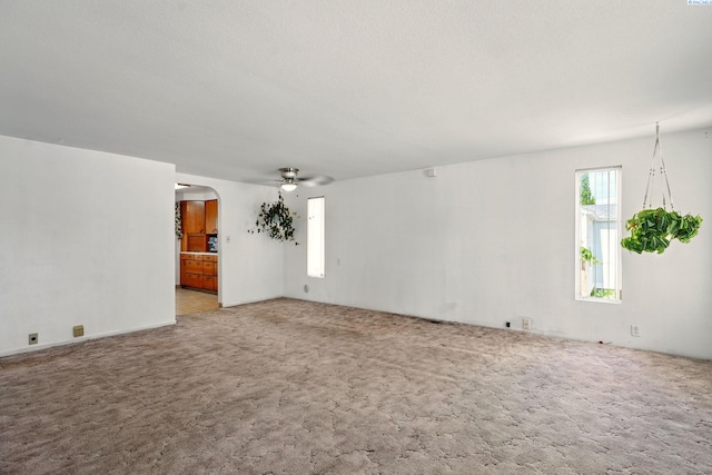 616 S Conway St, Kennewick, WA 99336 - unfurnished living room with carpet floors, arched walkways, and a ceiling fan