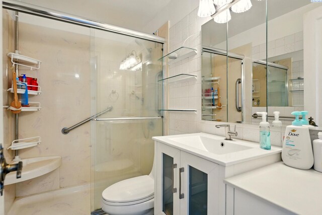 616 S Conway St, Kennewick, WA 99336 - full bathroom featuring a stall shower, toilet, vanity, tile walls, and decorative backsplash