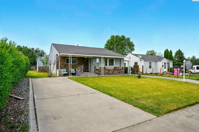 616 S Conway St, Kennewick, WA 99336 - ranch-style home with stone siding, a front lawn, a porch, and concrete driveway
