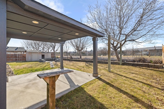 view of yard with an outbuilding, a fenced backyard, a patio, and a storage shed