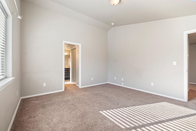 interior space with lofted ceiling, carpet, and baseboards