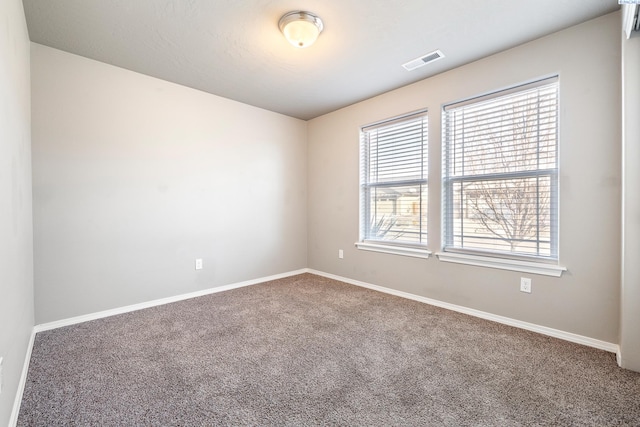 unfurnished room featuring carpet floors, baseboards, and visible vents