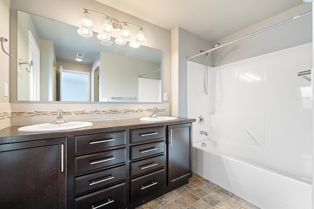 bathroom with shower / bathtub combination, double vanity, backsplash, and a sink