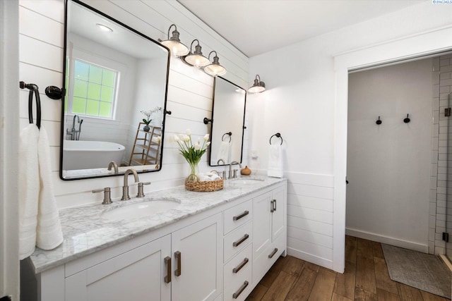 10219 W Argent Rd, Pasco, WA 99301 - bathroom with double vanity, wood-type flooring, a freestanding bath, a tile shower, and wainscoting