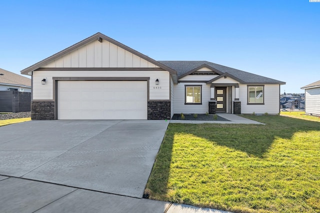 view of front of house with an attached garage, board and batten siding, stone siding, driveway, and a front lawn