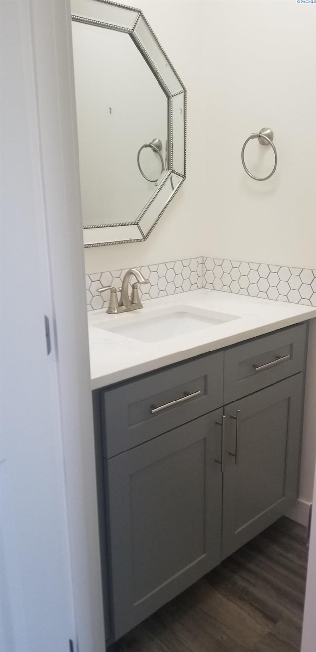 bathroom featuring vanity, hardwood / wood-style floors, and backsplash