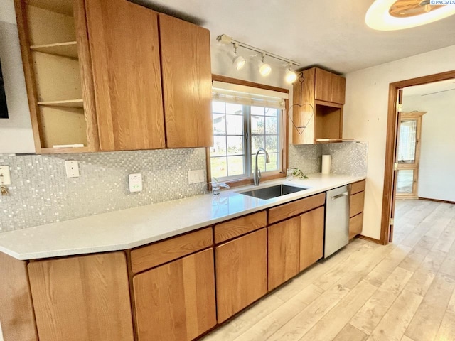 kitchen with light wood-type flooring, light countertops, a sink, and dishwasher