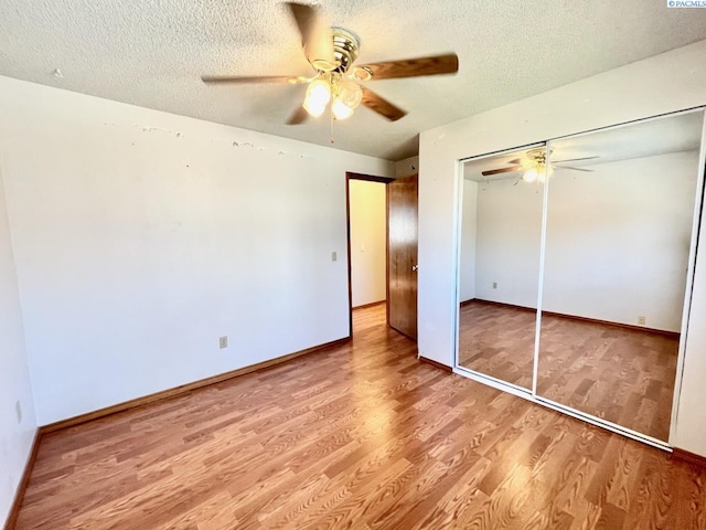 unfurnished bedroom featuring a textured ceiling, a closet, wood finished floors, and a ceiling fan