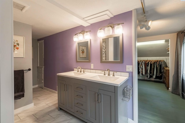 807 S Mill St, Colfax, WA 99111 - full bath with double vanity, baseboards, a walk in closet, and marble look tiles