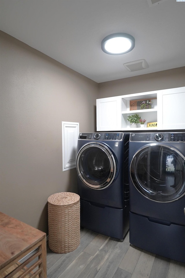 1135 SW Lost Trail Dr, Pullman, WA 99163 - laundry area with washing machine and dryer, light wood-style floors, and cabinet space