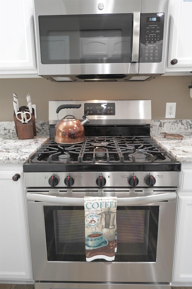 1135 SW Lost Trail Dr, Pullman, WA 99163 - detailed view of appliances with stainless steel finishes, white cabinetry, and light stone countertops